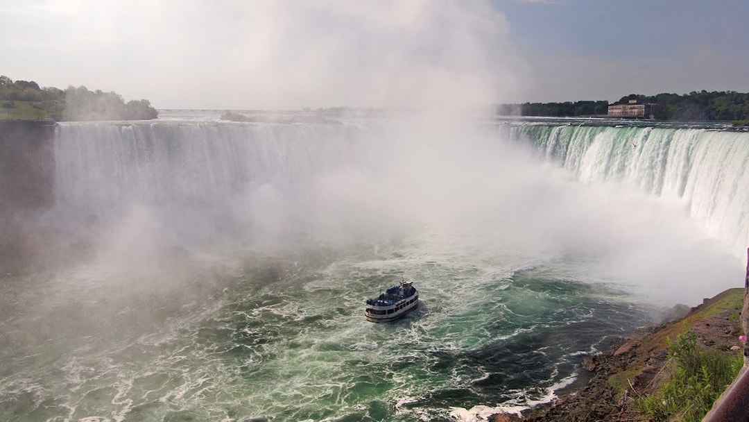 Boat approaching Niagara Falls surrounded by mist.