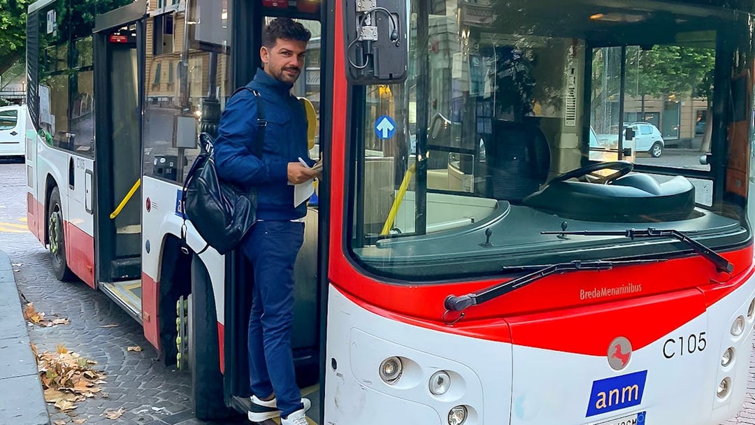Man boarding a bus for airport transfer between Naples Capodichino Airport and Naples Maritime Station.