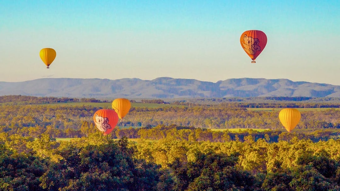 Hot air balloons over scenic landscape in Cairns, Australia.