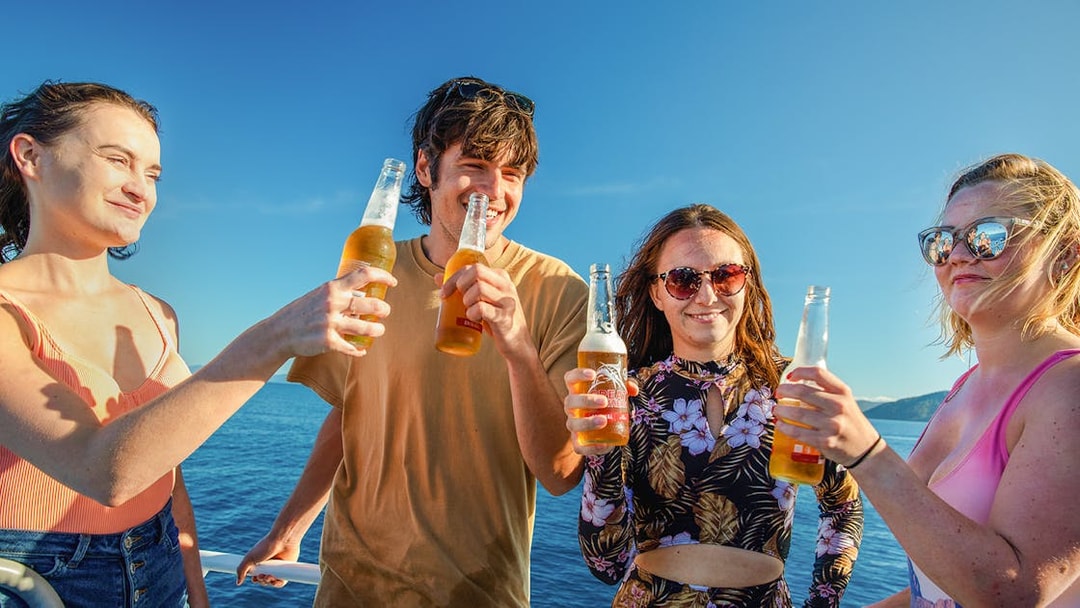 Group enjoying drinks on a boat during Fitzroy Island adventure.