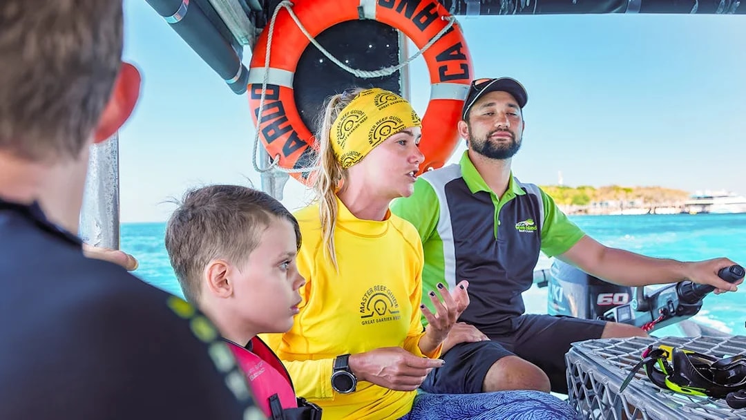 Tour guide explaining snorkeling options on a boat from Cairns to Green Island.