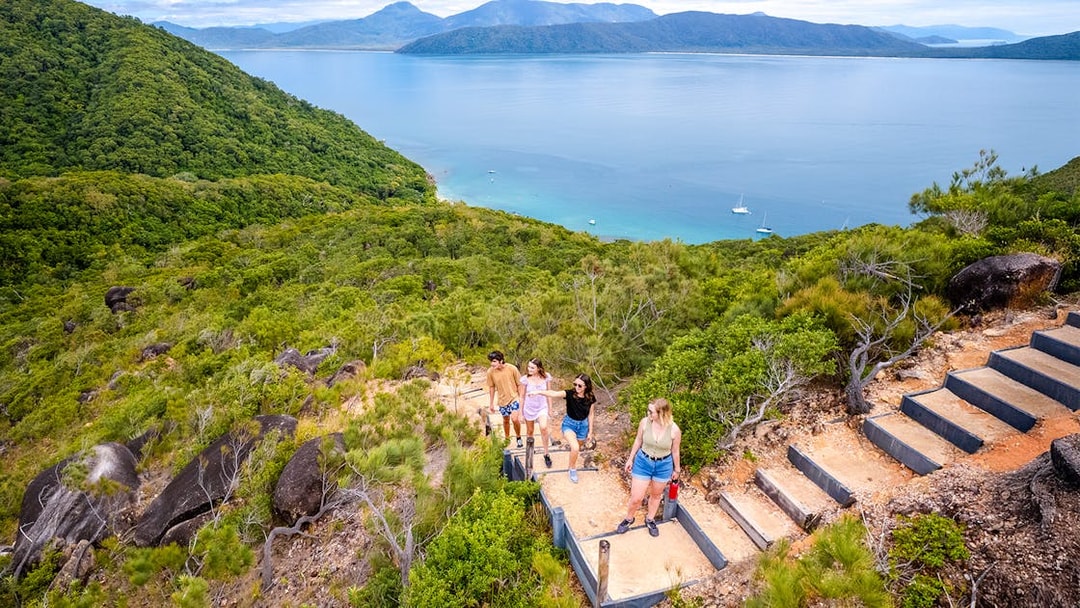 Hikers on a trail overlooking Fitzroy Island and Coral Sea near Cairns, Australia.
