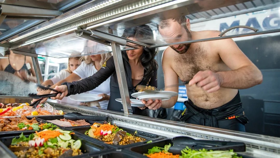 Guests enjoying buffet lunch on Cairns to Great Barrier Reef cruise.