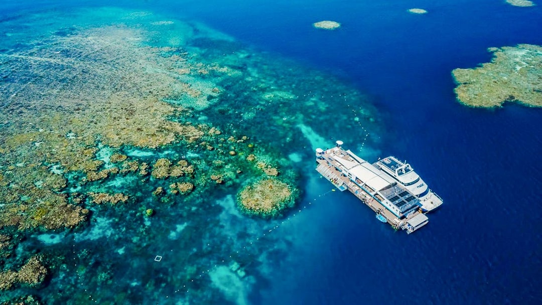 Aerial view of a pontoon at the Great Barrier Reef surrounded by vibrant coral formations.