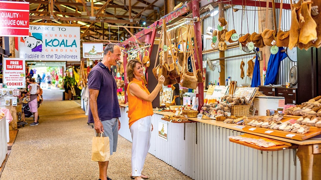 Couple shopping for local crafts at Kuranda markets on a tour from Cairns.