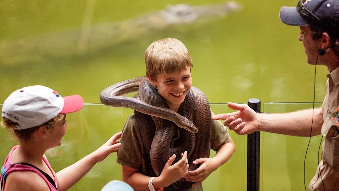 Boy holding a snake at Hartleys Crocodile Adventures, Queensland.