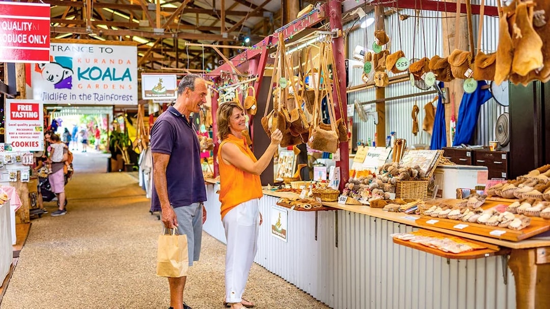 Couple shopping for local crafts at Kuranda markets on a tour from Cairns.