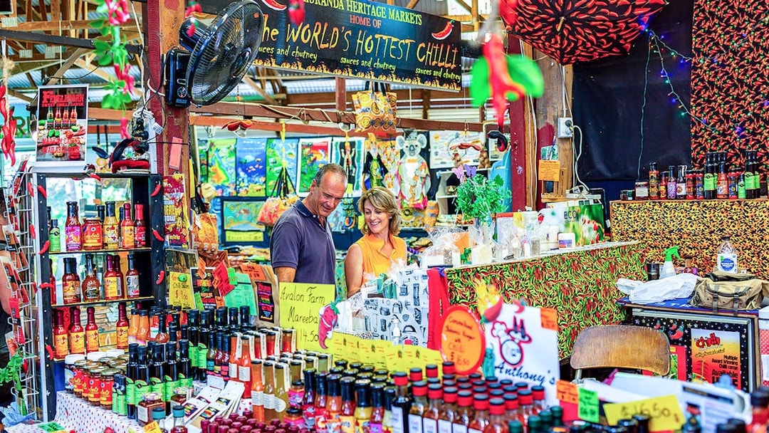 Couple exploring spice stall at Kuranda Heritage Market.