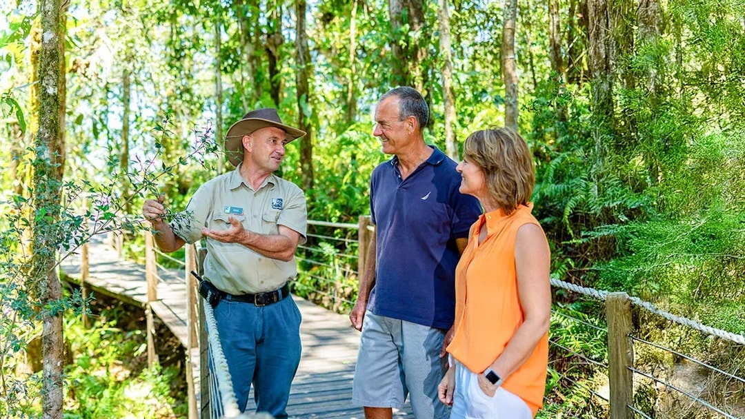 Guide explaining rainforest plants to tourists on Kuranda tour from Cairns.