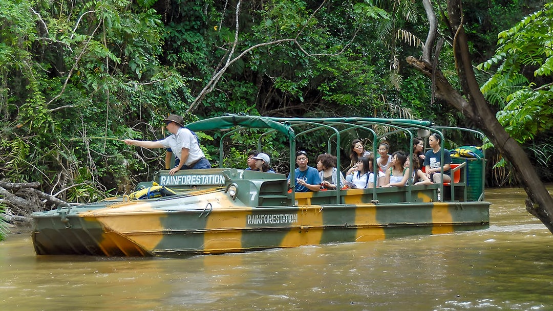 Tourists on an Army Duck boat exploring Kuranda waterways, Queensland rainforest.