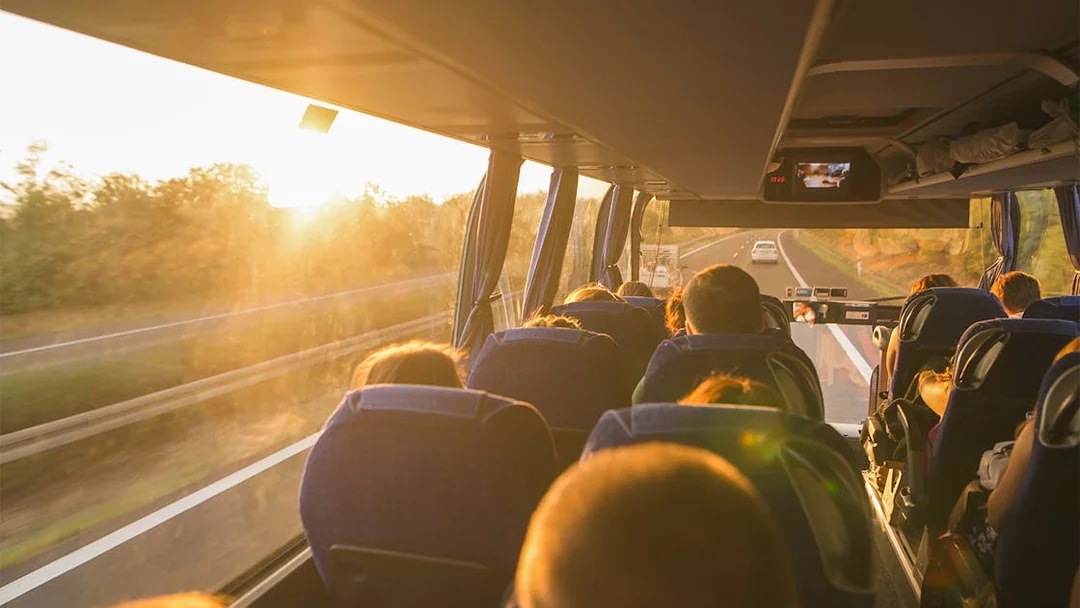 Passengers on a bus traveling to tandem skydiving in Cairns at sunset.