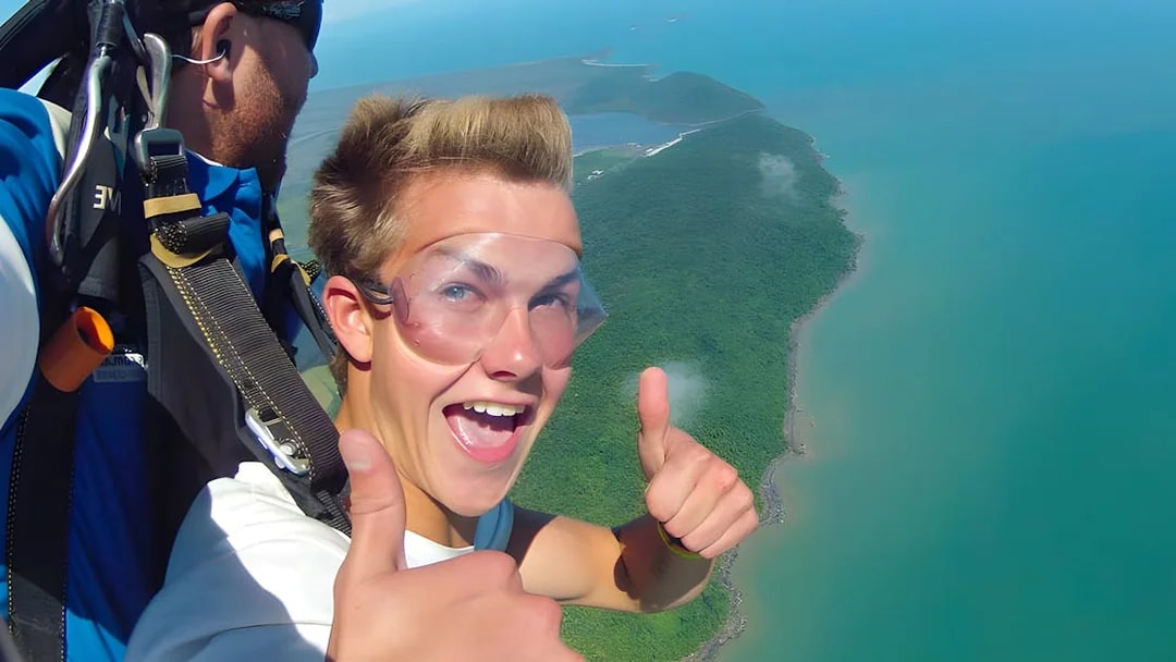 Tandem skydive over Cairns coastline with ocean and forest views.