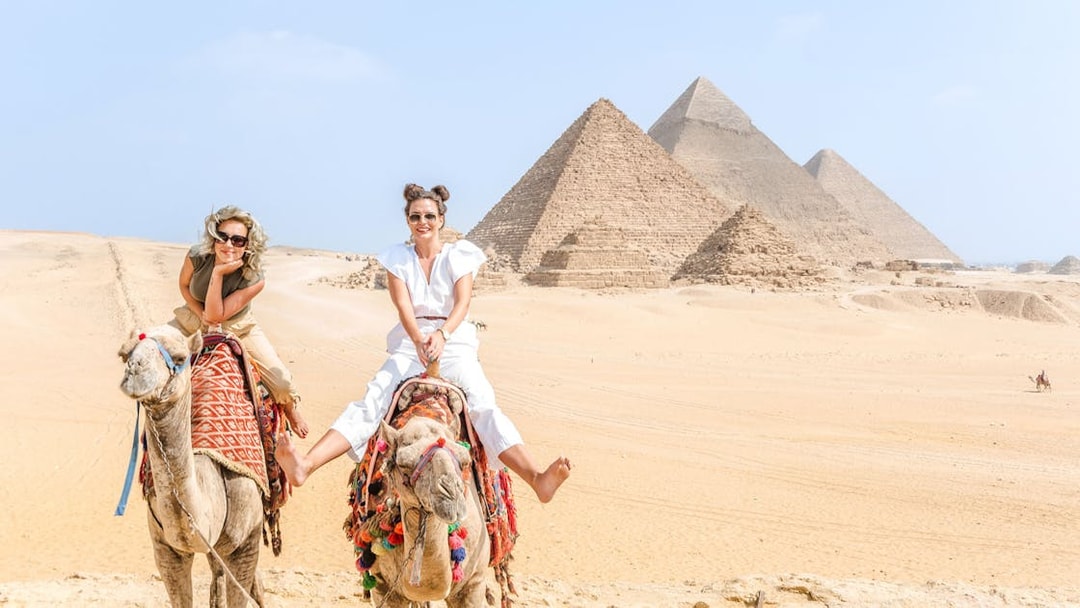 Tourists riding camels near the Giza Pyramids in Egypt.