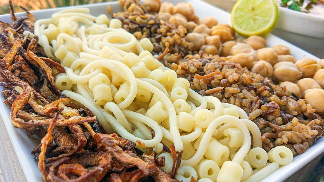 Koshari dish with pasta, rice, lentils, chickpeas, and fried onions, traditional Egyptian lunch.