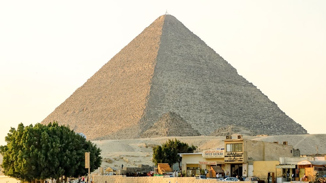 Giza Pyramid with nearby shops and tourists on a guided half-day tour.
