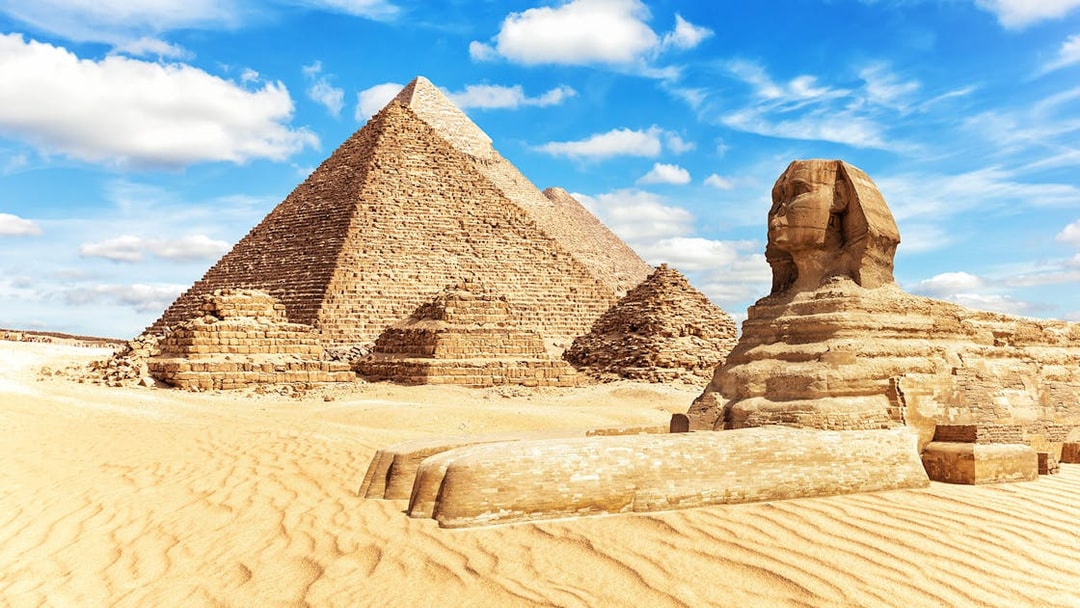 Giza Pyramids and Sphinx under blue sky on a half-day guided tour.
