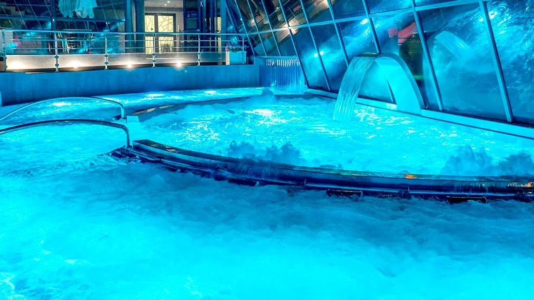 Caldea spa thermal pools with cascading water and mountain views in Andorra.