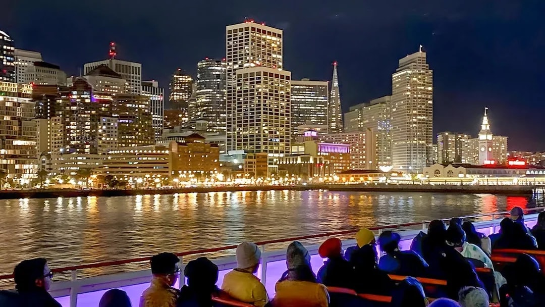Guests on deck viewing San Francisco skyline during California sunset cruise.