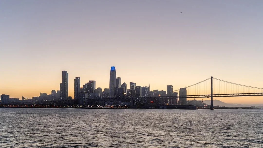 City skyline and bridge at sunset during California cruise.
