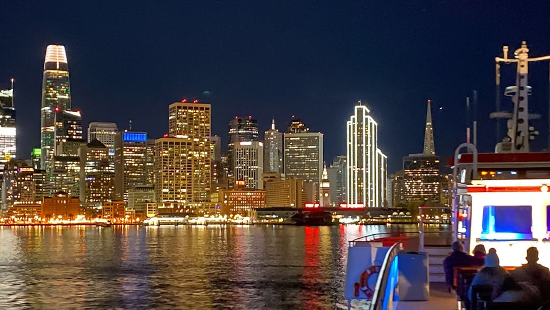 Guests on deck viewing San Francisco skyline during California Sunset cruise.