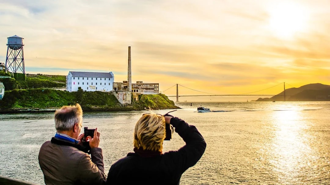 Guests photographing sunset near Alcatraz Island during California Sunset cruise.