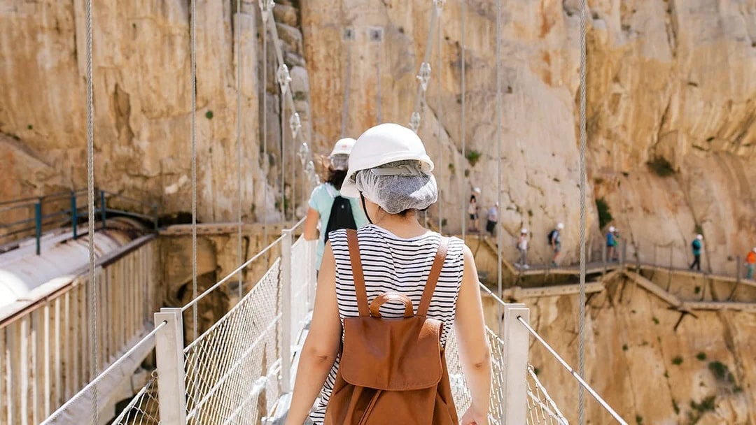 Visitors crossing a narrow bridge on the Caminito del Rey guided tour in Spain.