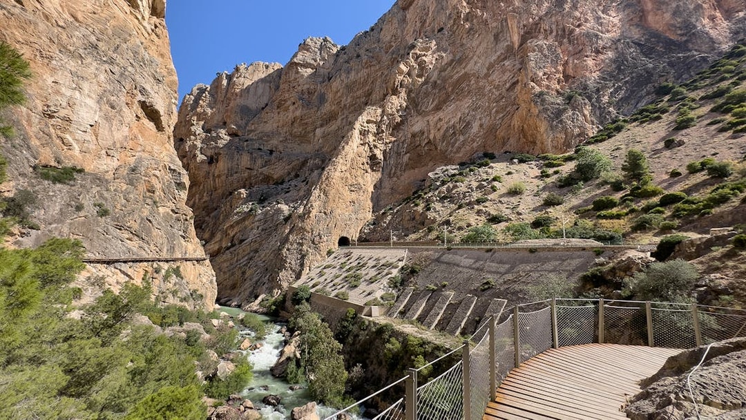 Caminito del Rey walkway through rocky gorge in Málaga, Spain, with river below.
