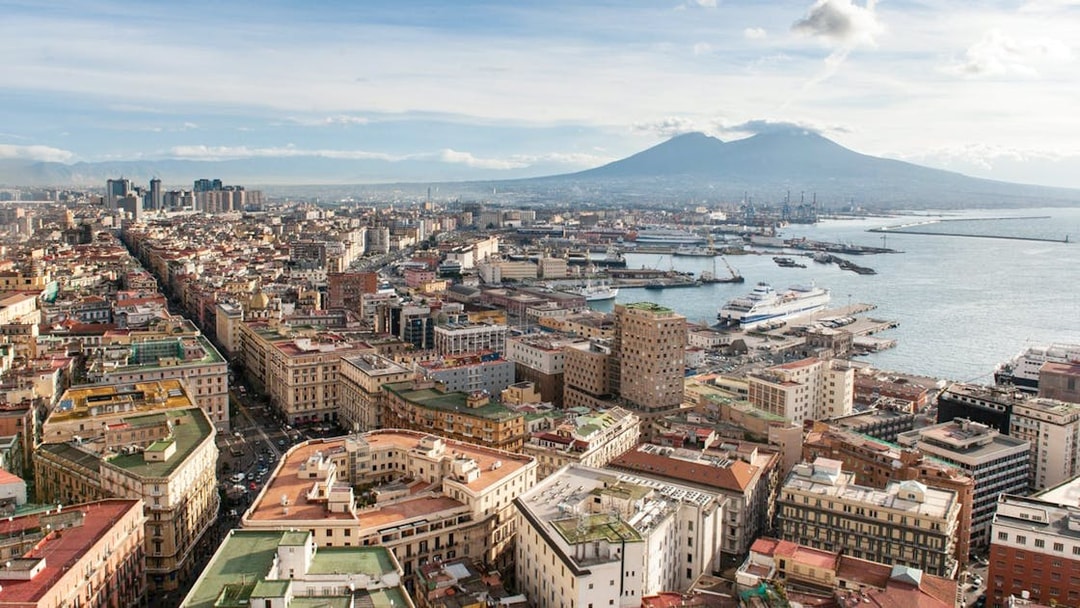 Aerial view of Naples with Mount Vesuvius in the background, near train transfer to Herculaneum.