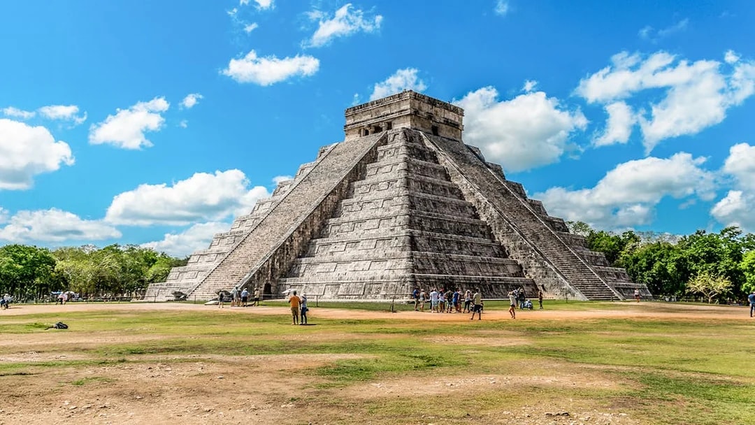 Chichen Itza pyramid with tourists exploring the site in Mexico.