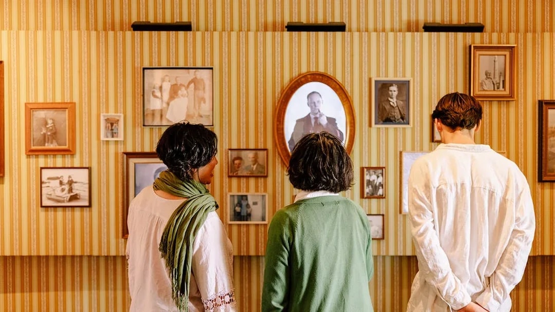 Visitors examining historical photographs at Cape Leeuwin Lighthouse exhibit.