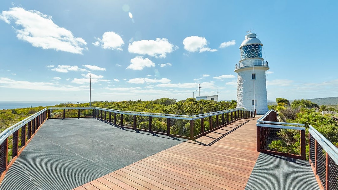 Boardwalk leading to Cape Naturaliste Lighthouse under sunny sky, Western Australia.