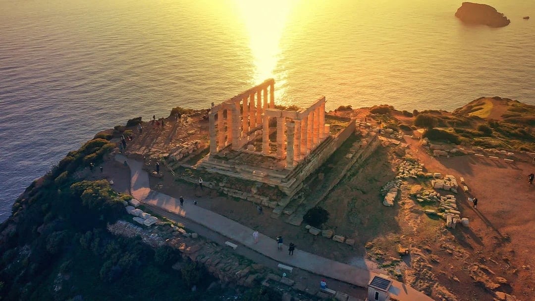 Temple of Poseidon at Cape Sounio overlooking the sea at sunset.