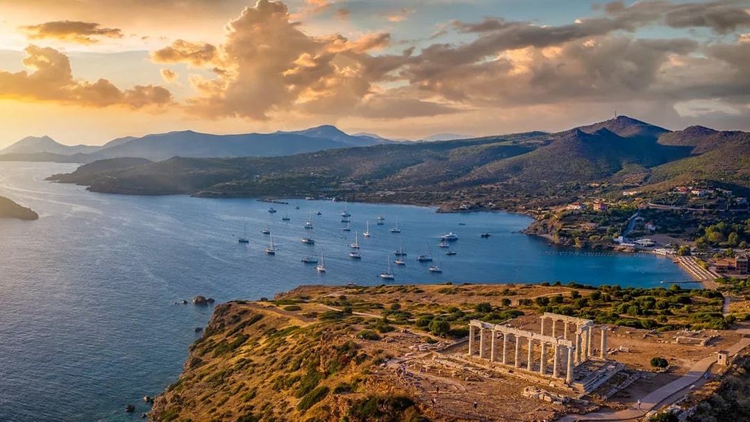 Temple of Poseidon at Cape Sounion with sunset over the Aegean Sea.