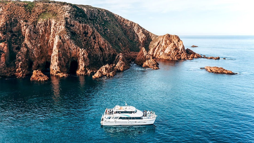 Cruise boat near Cape Woolamai cliffs, Phillip Island, morning view.