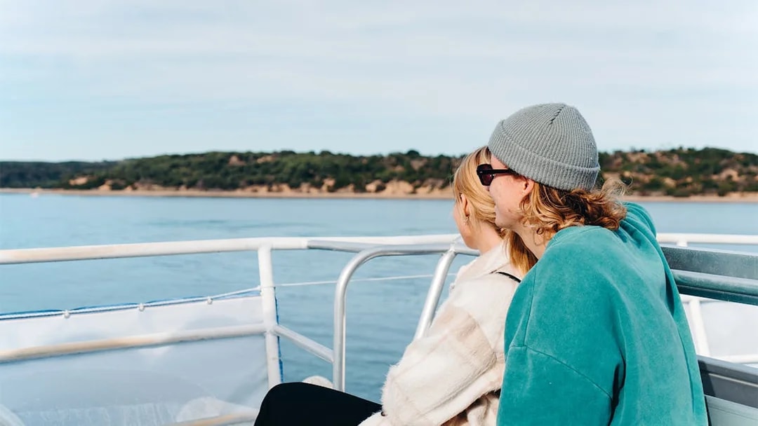 Couple enjoying Cape Woolamai coastline view from Phillip Island morning cruise.