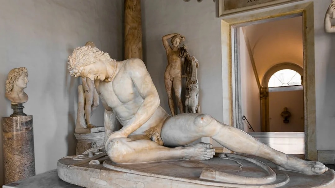 Dying Gaul statue in Capitoline Museum, Rome, depicting a wounded warrior in a classical setting.