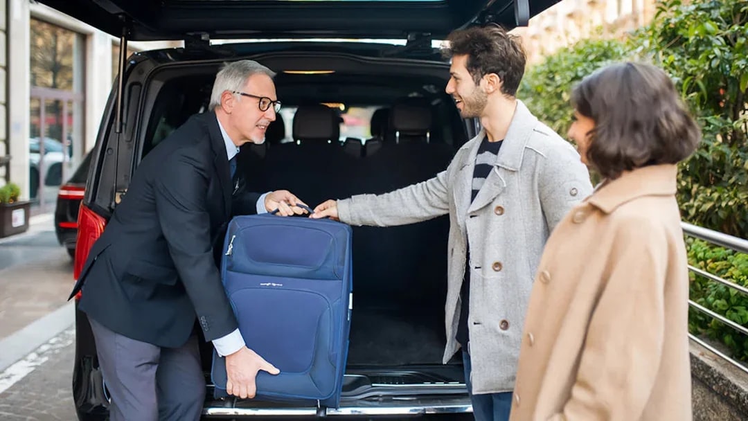 Shuttle driver assisting passengers with luggage for Cappadocia airport transfer.