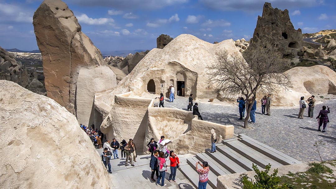 Visitors exploring rock formations at Göreme Open-Air Museum, Cappadocia.