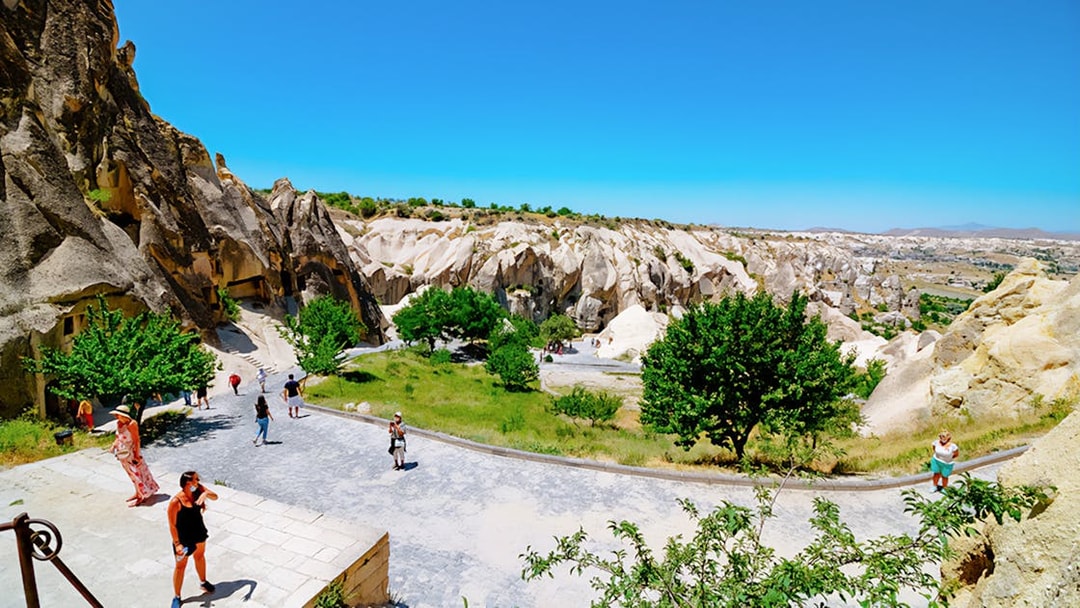 Visitors exploring Göreme Open-Air Museum with rock formations in Cappadocia.