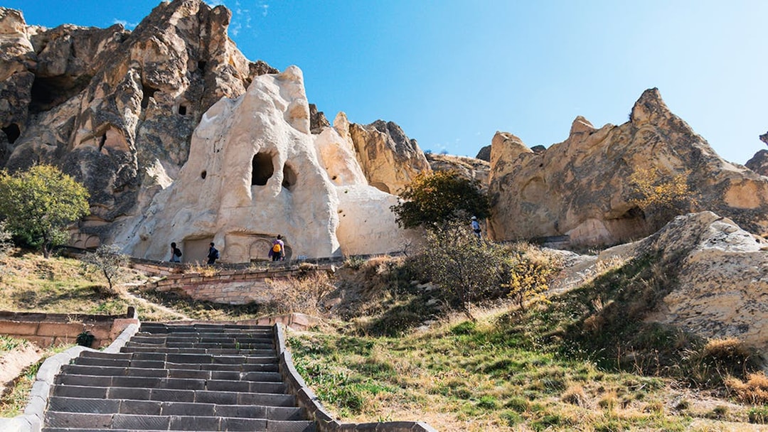 Göreme Open-Air Museum rock formations with tourists exploring, Cappadocia.