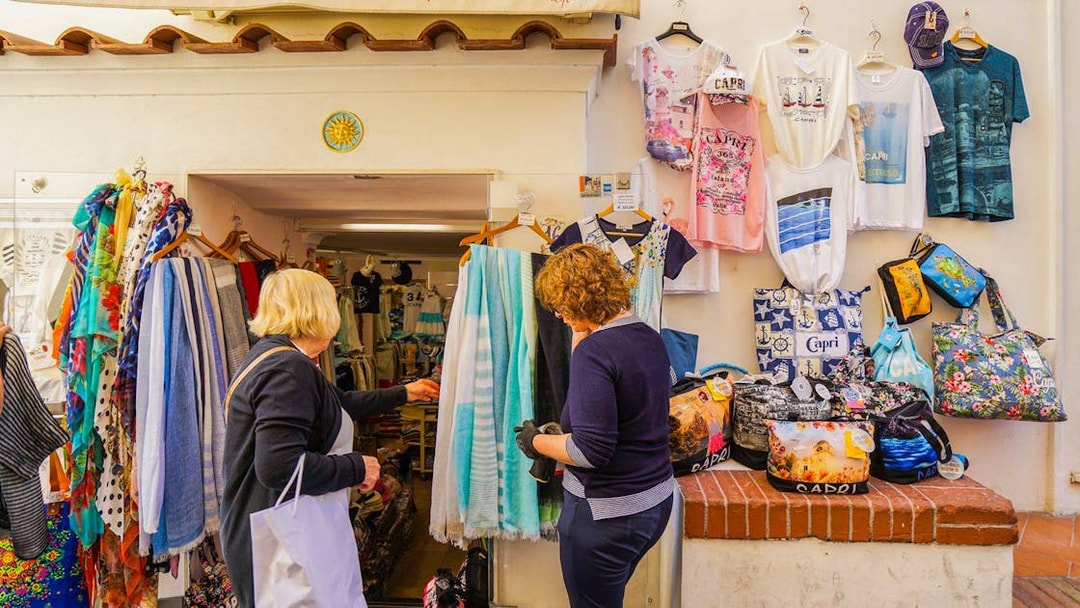 Tourists shopping for souvenirs at a local store on Capri Island during a guided tour.