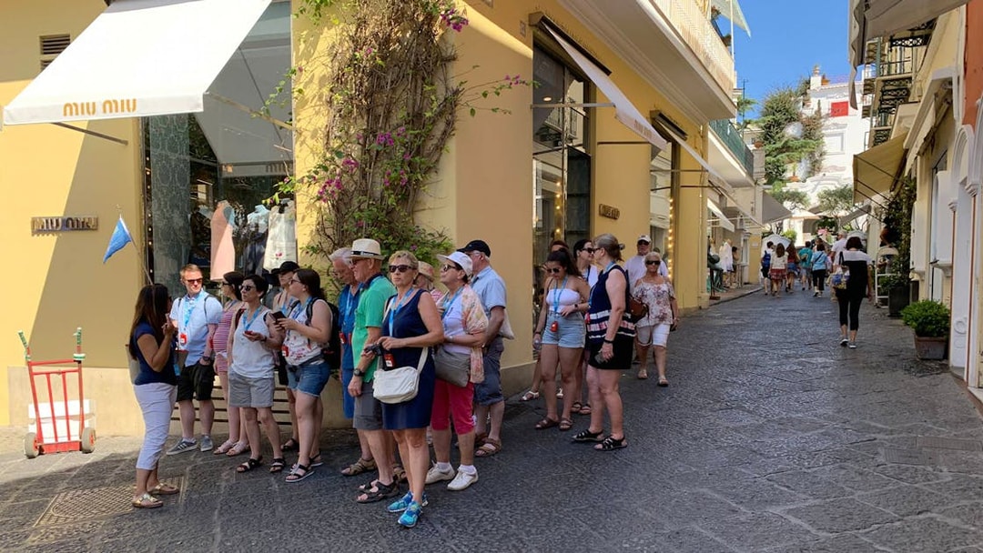 Tour group exploring a street on Capri Island during a guided tour with Sorrento transfers.