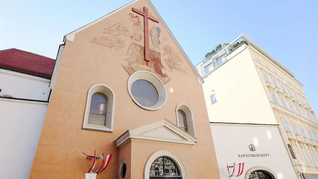 Minoritenkirche facade with fresco and cross in Vienna, Austria.