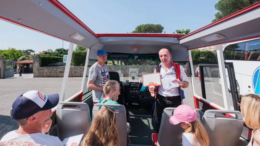 Tour guide speaking to visitors on a bus at Catacombs of Domitilla, Rome.
