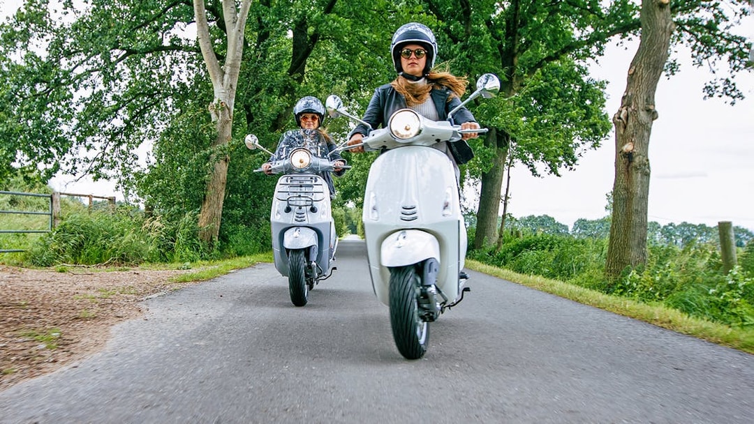 Motorbikes on a scenic road in Langkawi, surrounded by lush greenery.