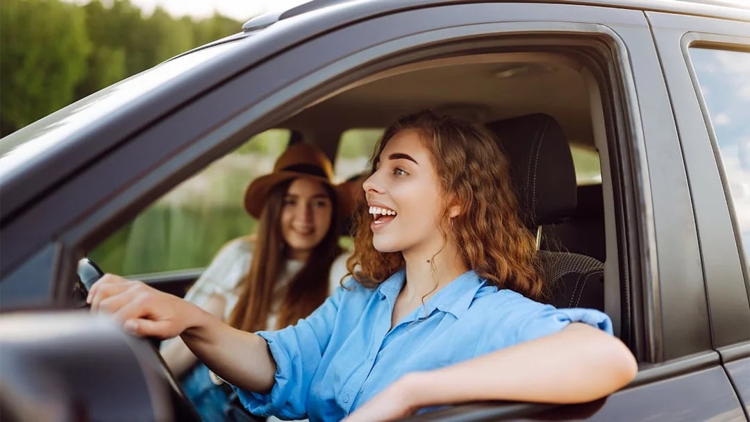Two women smiling in a car during a road trip in Langkawi.