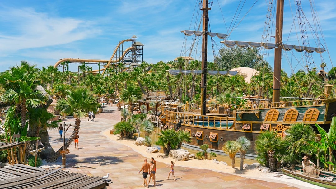 Caribe Bay view with pirate ship and water slides surrounded by palm trees.