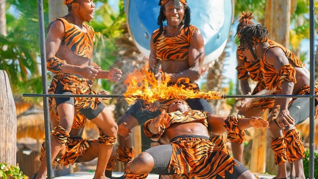 Performer limboing under a flaming bar at Caribe Bay.