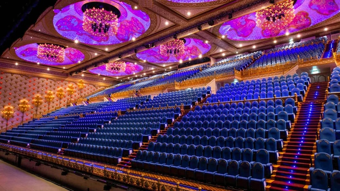 Grand theater seating at Carnival Magic Park in Phuket with ornate ceiling and chandeliers.