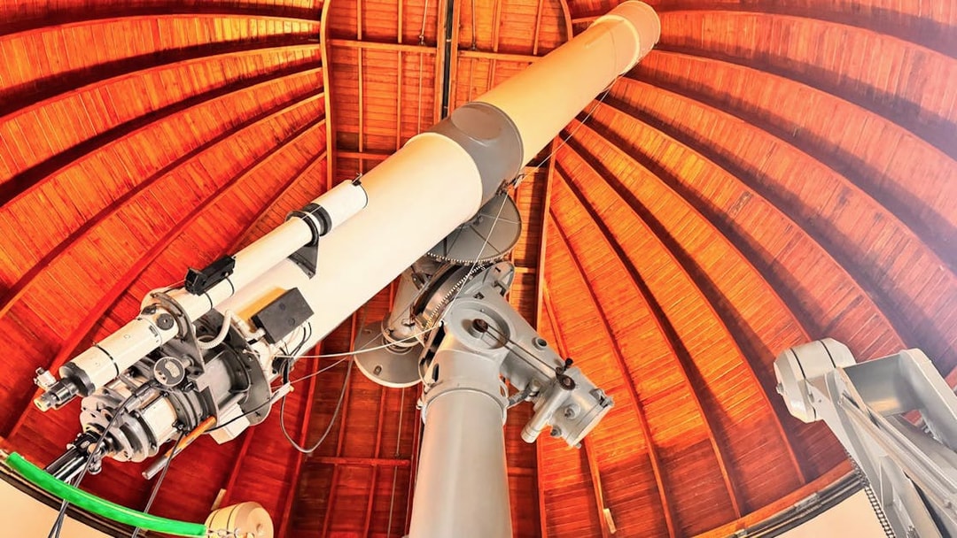 Telescope inside the Castle Gandolfo Observatory with wooden dome ceiling.